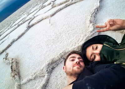 Owner and photographer of CandidSol and Her husband lying on the salt flats in Death Valley in California.